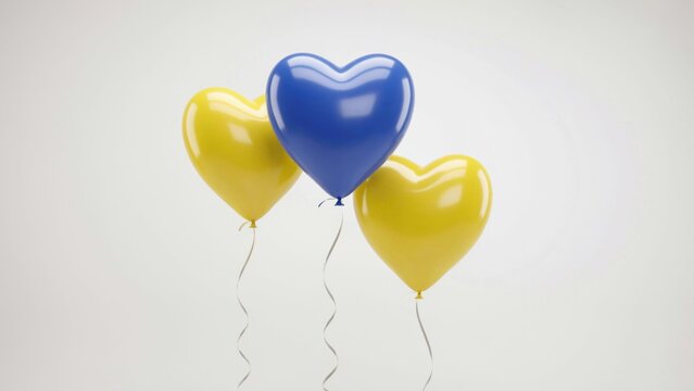 Three heartshaped balloons in yellow and blue colors isolated on white background