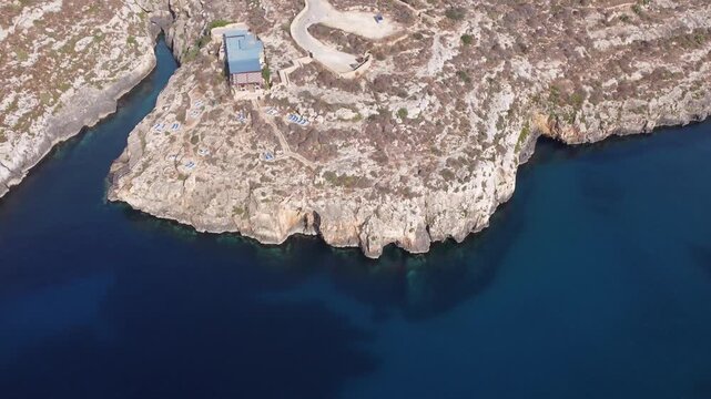 Ix-xini, Gozo, Malta - serene aerial view of rocky coastline with rugged terrain and blue water in natural landscape. High quality 4k footage