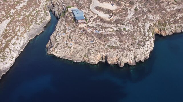 Ix-xini, Gozo, Malta - serene aerial view of rocky coastline with rugged terrain and blue water in natural landscape. High quality 4k footage
