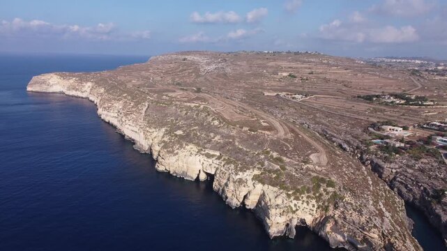 Ix-xini, Gozo, Malta - serene aerial view of rocky coastline with rugged terrain and blue water in natural landscape. High quality 4k footage