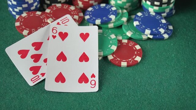 Playing cards with hearts suit and poker chips on green felt table, showing progression from one card to four cards in a game setting