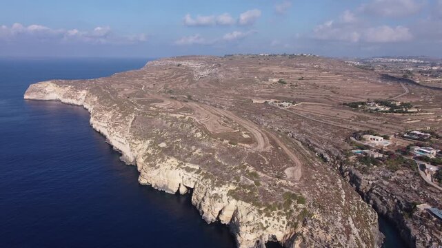 Ix-xini, Gozo, Malta - serene aerial view of rocky coastline with rugged terrain and blue water in natural landscape. High quality 4k footage