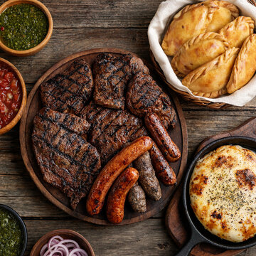 Traditional argentine parrillada platter with grilled meat sausages and empanadas on wood