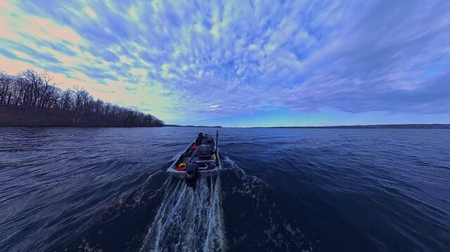 Two anglers cruising at large lake during cloudy spring day looking for fishing spot. Peaceful retreat from the busy life routine. Couple relaxing in utility boat, trolling on beautiful lake water.