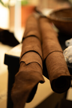 Rollos de cuero artesanal en taller de marroquiner&iacute;a con enfoque selectivo y luz c&aacute;lida