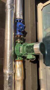Condensation water dripping from industrial pump and insulated cooling pipes