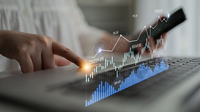 A businessperson interacts with a laptop displaying stock market graphs and data. This image captures the essence of financial analysis and investment strategies in a modern workspace. Scalp