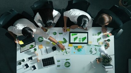 Naklejka premium Top view of executive manager hold tablet display clean energy at meeting. Aerial view of business people working together to plan and invest in sustainable environmental investment. Alimentation.