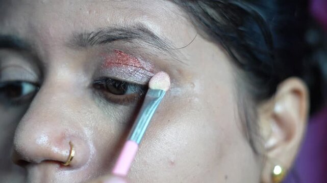 Detail of Indian Woman Doing Eyeshadow Makeup with Applicator Brush. Professional Eye Makeup Routine on Female Model Beauty and Wellness Concept.