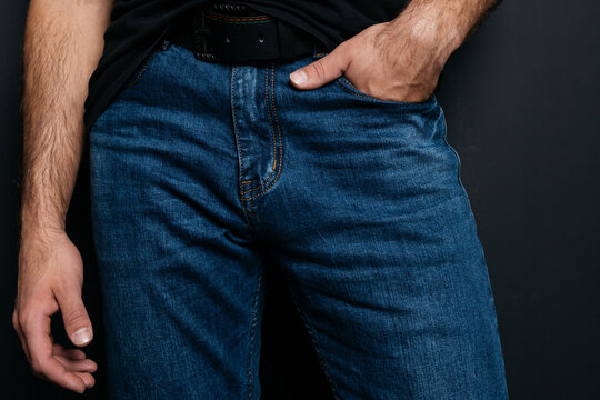 a young guy with skinny legs in jeans, below the waist: a fly and pockets for money or condoms. a pose from psychology: waiting in a store queue or on a date with a girl. street style in clothing: cla