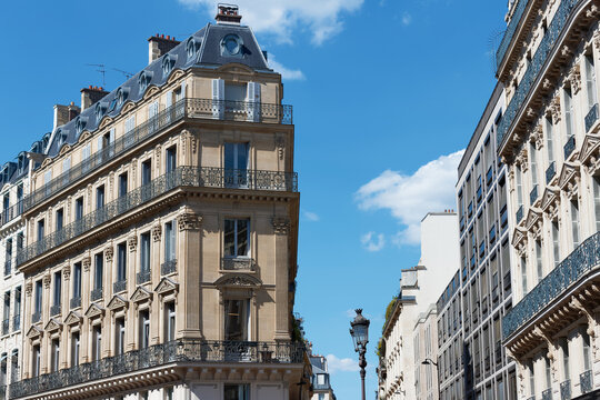 Magnificent Haussmann-style apartment buildings line the Avenue de l'Opera in the 2nd district of Paris, under a vivid blue sky.