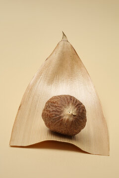 Still life with nutmeg on natural bamboo sheath shiny. Close-up with maximum depth of field on light background.