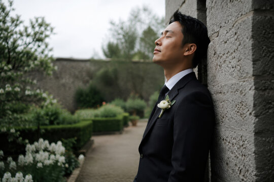 Calm groom waiting before the wedding ceremony in a romantic outdoor setting. Suits bridal branding, venue advertising, and wedding website banners.