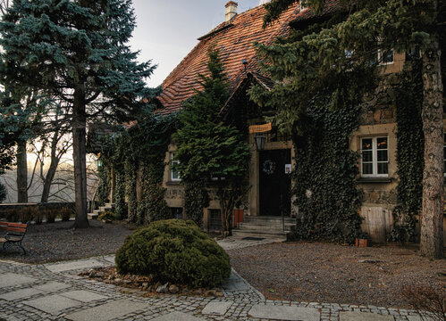 WALBRZYCH, POLAND - JANUARY 2025 Side entrance to a historic building with tiled roof covered in ivy on the grounds of Ksiaz Castle.