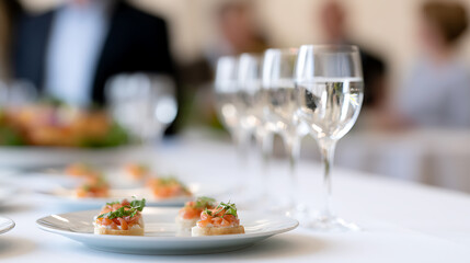 Fototapeta premium Elegant table setting with gourmet appetizers and water glasses, ready for a sophisticated event or celebratory gathering indoors