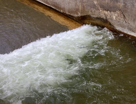 The flowing water from the dam spillway.