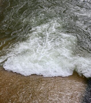 The flowing water out of the dam spillway.