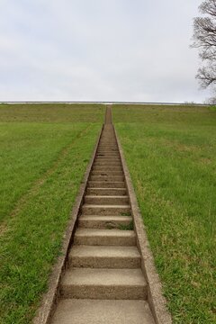 The cement steps up the hill on a cloudy day.