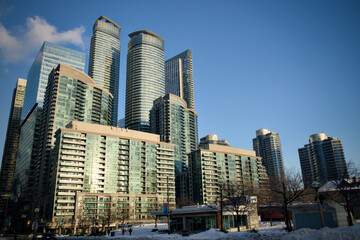 Modern residential towers cluster along the waterfront under a clear blue sky in Toronto, Canada © Moiseii Production