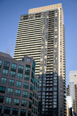 Naklejka premium A tan colored high-rise apartment tower stands tall in downtown Toronto, Canada