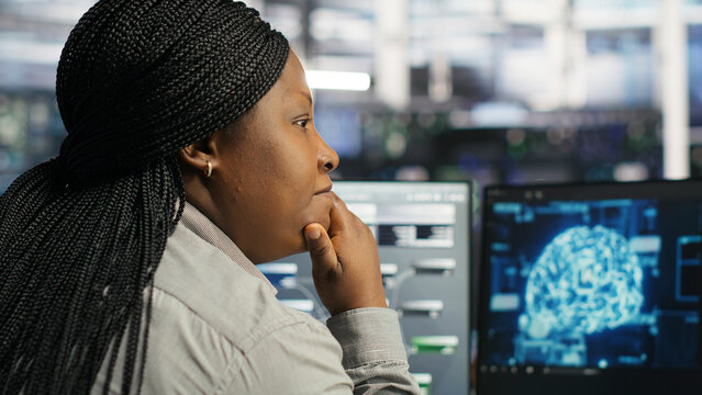 Server facility computing specialist applying AI ML models to set up hardware. IT specialist working with AI programming languages on workstation in server environment, optimizing system.
