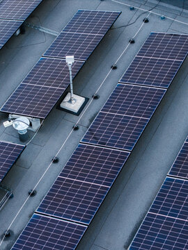 Aerial view of solar panels installed on a flat roof with rows of photovoltaic modules and mounting hardware in Ikskile, Ogre Municipality, Latvia.