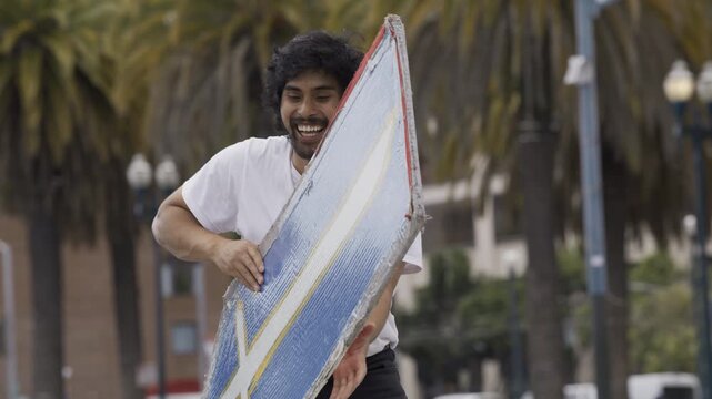 Man Swinging And Flipping Blue Cross Board In San Francisco Plaza - Medium, Slow Motion Shot