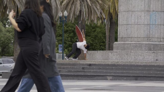 Athlete Doing Professional Tricks on Granite Plaza Steps With Pedestrians Passing By
