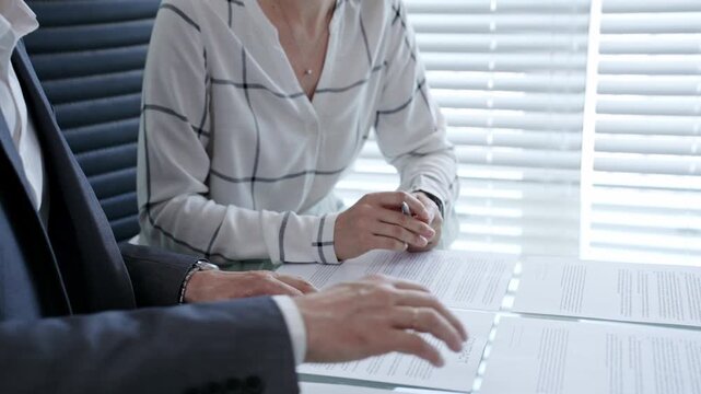 Business professional meticulously examining a legal document or contract with a magnifying glass. Emphasizing key clauses and fine print. While a colleague or client waits to review the agreement