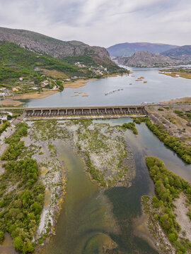 Aerial view of the Vau i Dejes Hydroelectric Power Station spanning the Drin River with its artificial lake and dam infrastructure in Vau i Dejes, Qarku i Shkodres, Albania.