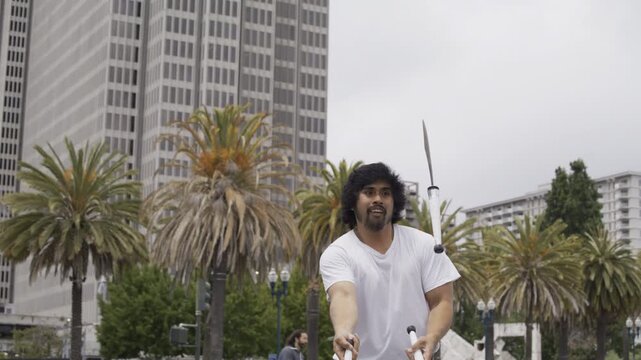 Street Juggler Tossing Knives Outdoors In San Francisco Plaza - Medium Steady Cam Shot
