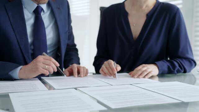 Business people hands discussing contract terms and analyzing paperwork, reviewing legal documents during a corporate meeting in a modern office, planning strategy