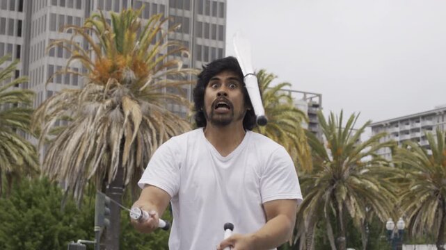 Juggler Catching Knives In San Francisco Plaza And Pretending To Be Scared - Slow Motion Medium Shot