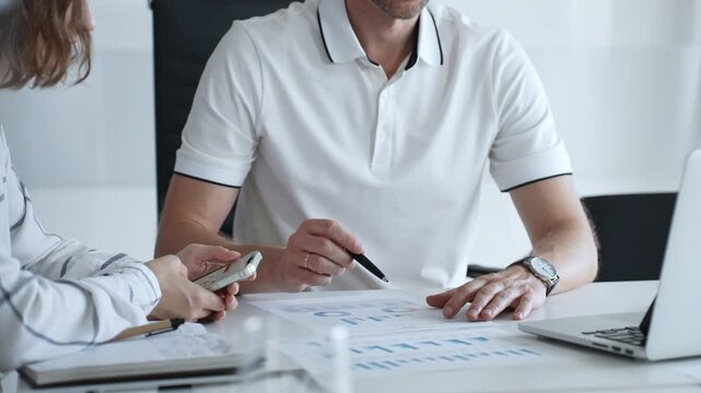 Professional colleagues working together at sleek workspace, reviewing financial metrics and brainstorming corporate expansion plans with collaborative energy, close up