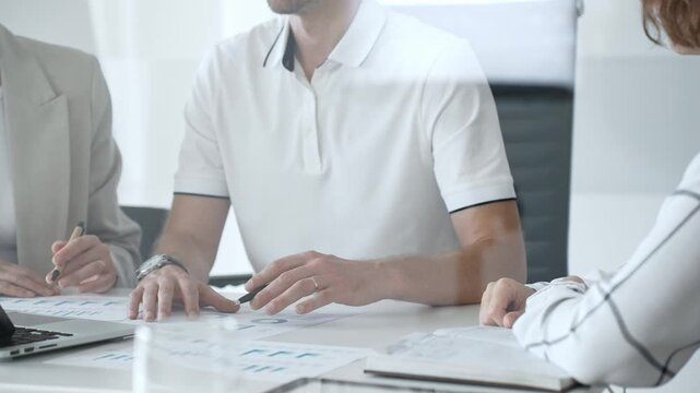 Professional colleagues working together at sleek workspace, reviewing financial metrics and brainstorming corporate expansion plans with collaborative energy, close up