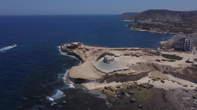 Xwejni s centuries-old salt pans unfold along the rugged coast of Zebbug, Gozo, geometric pools and vivid Mediterranean blues in a sweeping summer Aerial view. High quality 4k footage