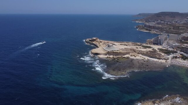 Xwejni s centuries-old salt pans unfold along the rugged coast of Zebbug, Gozo, geometric pools and vivid Mediterranean blues in a sweeping summer Aerial view. High quality 4k footage