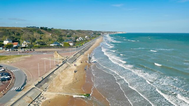 Wide drone shot of Omaha Beach in Normandy, France, with Les Braves memorial, long sandy beach and waves on the historic D-Day shore