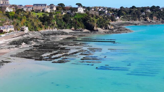 Aerial drone view of oyster farm structures on the coast near Cancale, France, highlighting shellfish aquaculture and seafood production