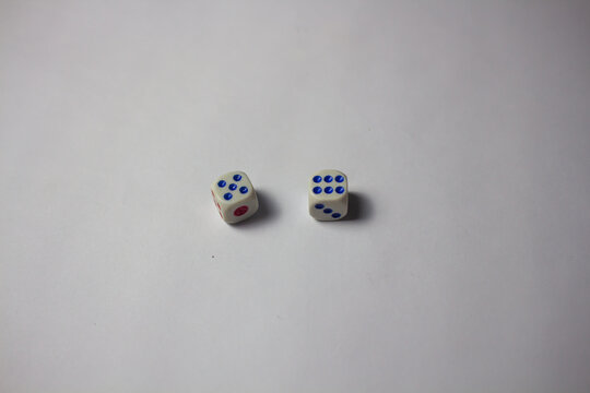 Two white dice showing numbers five and six on a clean white background