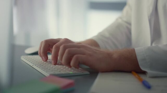 close up of a doctor hands typing on a laptop
