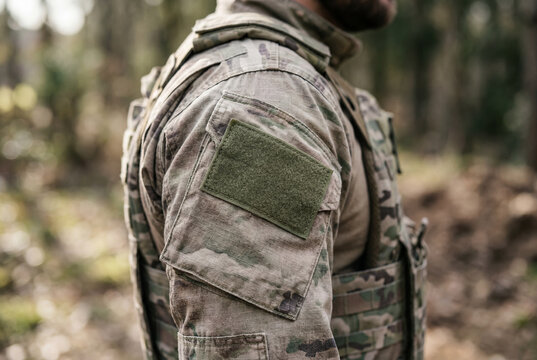 Close up of tactical camouflage uniform sleeve with blank velcro patch in forest