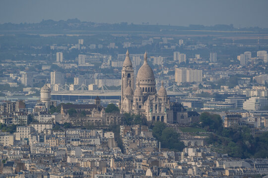 Aerial view of the iconic Sacre-Coeur Basilica in Montmartre overlooking the dense urban landscape of Paris, Ile-de-France, France.