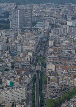 Aerial view of the Paris Metro elevated railway line running through the dense urban landscape of central Paris, featuring historic buildings and tree-lined streets, Paris, Ile-de-France, France.
