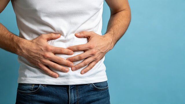 Man holding stomach in pain, suffering from abdominal cramps, digestive issues, health problems concept on blue background