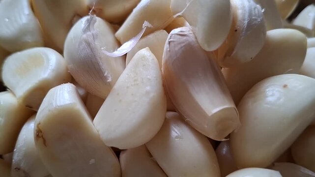 Close up view of a pile of fresh peeled raw garlic cloves.