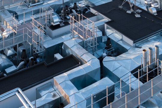 Aerial view of AI Data Center Cooling system featuring complex metallic ventilation ducts, industrial pipes, and maintenance platforms on a flat roof in Poland.