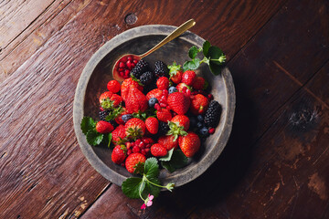 Fresh Mixed Berries in Rustic Wooden Bowl on Dark Wood Table © ccc