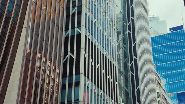A dynamic view of modern urban skyscrapers in Hong Kong, showcasing their verticality and sleek design