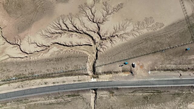 Top-down drone view of tree-shaped erosion pattern and road in Tibet, China